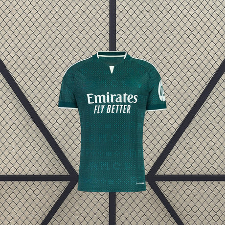 Vista frontal de la camiseta R.M. 26-27 visitante en verde oscuro, con patrón tonal, cuello abierto con ribete blanco y manga corta