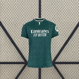 Vista frontal de la camiseta R.M. 26-27 visitante para mujer en verde oscuro, con patrón tonal, manga corta y cuello con abertura