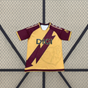 Vista frontal de la camiseta Rayo Vallecano 26-27 3ª equipación en amarillo dorado con diseño diagonal granate, mangas granates y detalles amarillos
