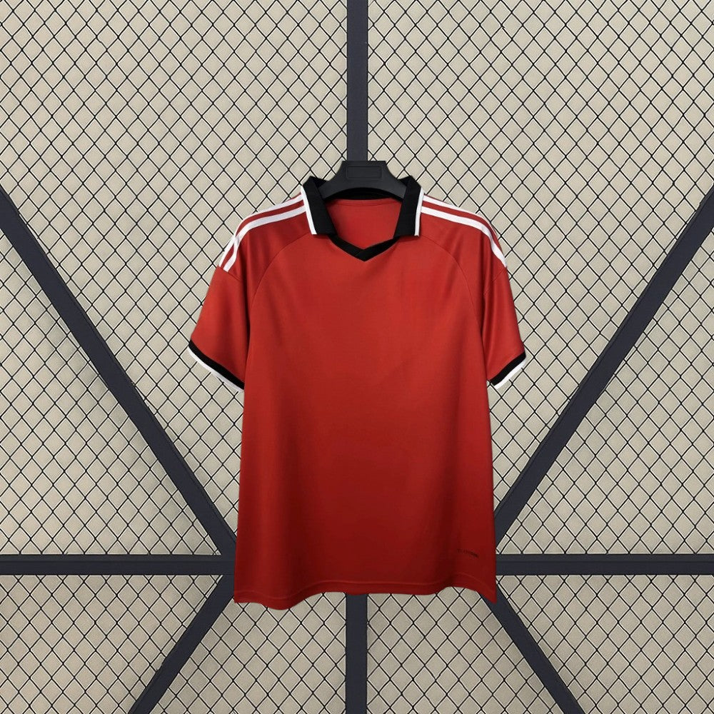 Vista frontal de la camiseta Sevilla 26-27 visitante en color rojo, con cuello tipo polo negro, franjas blancas en los hombros y manga corta
