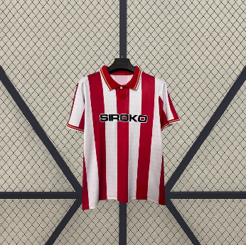 Vista frontal de la camiseta Sporting de Gijón 26-27 local con franjas verticales rojas y blancas, cuello tipo polo y manga corta