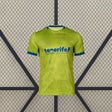 Vista frontal de la camiseta Tenerife 26-27 tercera equipación en amarillo lima con cuello y puños azules y patrón tonal