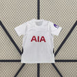 Vista frontal de la camiseta Tottenham 26-27 local blanca con textura tonal, manga corta, cuello geométrico y paneles laterales azul marino