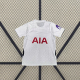 Vista frontal de la camiseta Tottenham 26-27 local blanca con textura tonal, manga corta, cuello geométrico y paneles laterales azul marino