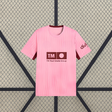 Vista frontal de la camiseta Valencia 26-27 tercera equipación en color rosa con cuello redondo, manga corta y detalles granate
