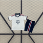 Vista frontal de la equipación Bayern Munich 26-27 visitante para niño con camiseta blanca, cuello azul marino y pantalón corto azul marino