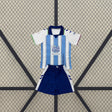 Vista frontal de la equipación Málaga niño 26-27 local con camiseta blanca y azul claro y pantalón azul marino