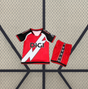 Vista frontal de la equipación Rayo Vallecano 26-27 visitante para niño con camiseta roja, diseño diagonal blanco, mangas negras y pantalón corto rojo