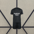 Vista frontal de la equipación Real Sociedad 26-27 visitante para niño con camiseta negra de manga corta y pantalón corto negro