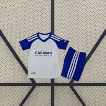 Vista frontal de la equipación Zaragoza 26-27 local para niño con camiseta blanca de mangas azules y pantalón corto azul con franjas blancas