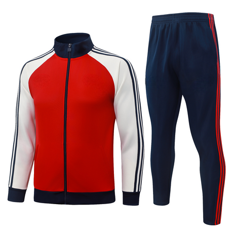 Vista frontal del chándal Arsenal 26-27 Modelo 1 con chaqueta roja de cremallera completa, mangas blancas y pantalón azul marino