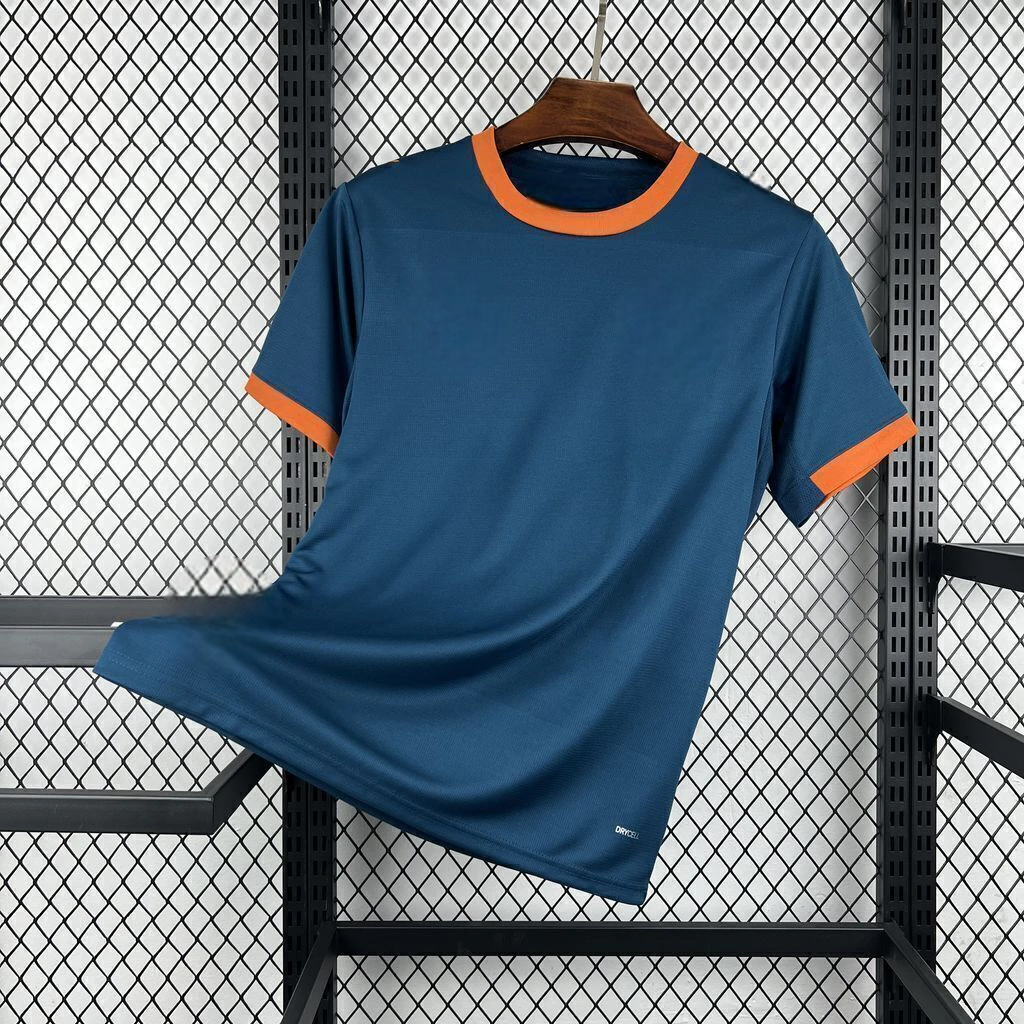 Vista frontal en diagonal de la camiseta Valencia 26-27 visitante en azul oscuro, con cuello redondo y puños naranjas