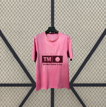 Vista frontal en percha de la camiseta Valencia 26-27 tercera equipación rosa con acabado tonal y ribetes granate