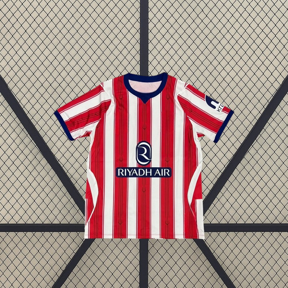 Vista frontal extendida de la camiseta Atlético de Madrid 26-27 local, con rayas rojas y blancas, detalles azules y paneles laterales claros