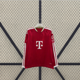 Vista frontal extendida de la camiseta Bayern Munich 26-27 local de manga larga, con diseño rojo texturizado y franjas blancas en las mangas