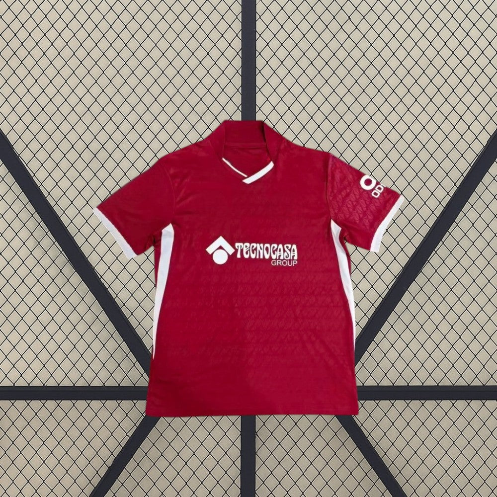Vista frontal extendida de la camiseta Getafe 26-27 visitante, con base granate, ribetes blancos y paneles laterales en contraste