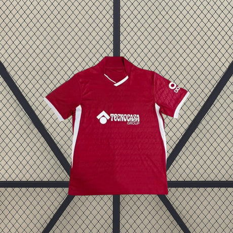 Vista frontal extendida de la camiseta Getafe 26-27 visitante, con base granate, ribetes blancos y paneles laterales en contraste