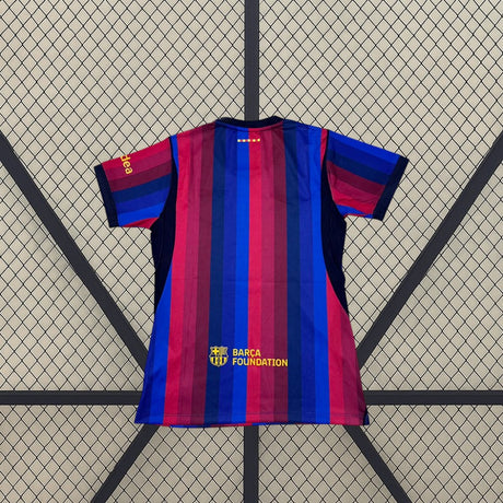 Vista trasera de la Camiseta Barcelona mujer 26-27 local con franjas azul y grana y detalle amarillo inferior