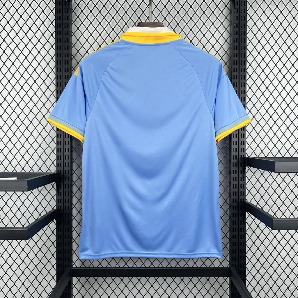 Vista trasera de la Camiseta Como 26-27 edición especial en azul celeste con cuello blanco y detalles amarillos