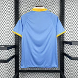 Vista trasera de la Camiseta Como 26-27 edición especial en azul celeste con cuello blanco y detalles amarillos