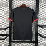 Vista trasera de la camiseta AC Milan 26-27 3ª equipación negra con detalles rojos en el cuello y los remates de las mangas