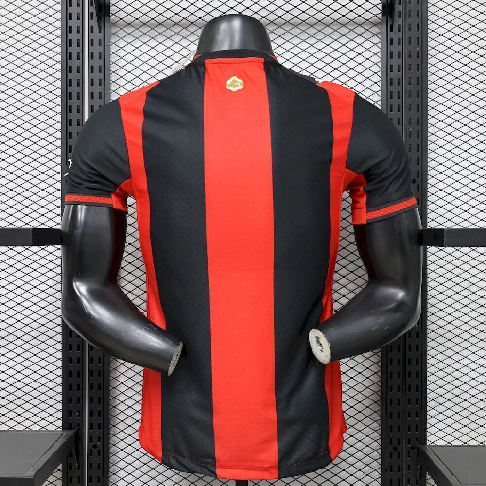 Vista trasera de la camiseta AC Milan 26-27 local versión Player con franjas verticales rojas y negras y paneles laterales