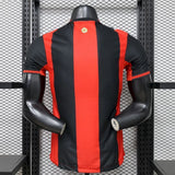 Vista trasera de la camiseta AC Milan 26-27 local versión Player con franjas verticales rojas y negras y paneles laterales
