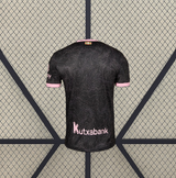 Vista trasera de la camiseta Alavés 26-27 visitante en negro, con textura de líneas tonales y detalles rosas en cuello y puños