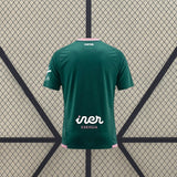 Vista trasera de la camiseta Albacete 26-27 Visitante verde con detalle rosa en el cuello y acabados rosas en la parte inferior