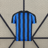 Vista trasera de la camiseta Atalanta 26-27 local con franjas azules y negras y panel superior oscuro sobre hombros y cuello