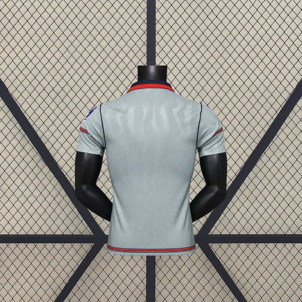 Vista trasera de la camiseta Atlético de Madrid 26-27 3ª equipación Player Version gris verdosa con patrón tonal y cuello azul marino y rojo