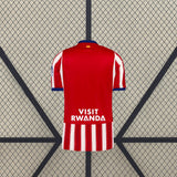 Vista trasera de la camiseta Atlético de Madrid 26-27 local, con parte superior roja lisa y parte inferior con franjas rojas y blancas