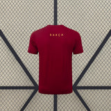 Vista trasera de la camiseta Barcelona 26-27 de entrenamiento en granate con mangas cortas y detalle amarillo en la parte superior de la espalda