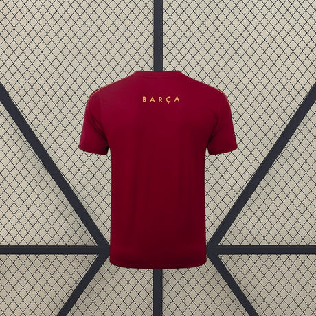Vista trasera de la camiseta Barcelona 26-27 de entrenamiento en granate con mangas cortas y detalle amarillo en la parte superior de la espalda