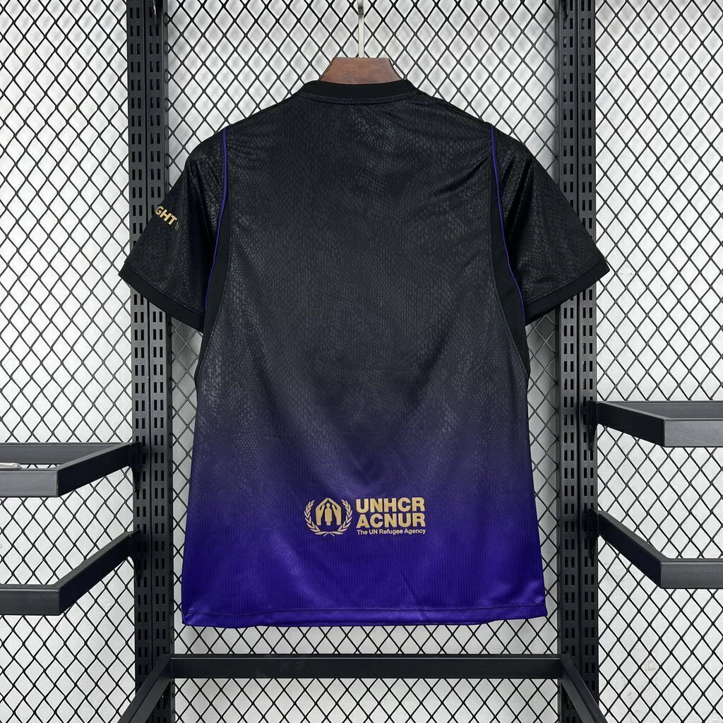 Vista trasera de la camiseta Barcelona 26-27 visitante, con degradado de negro a morado y detalle dorado en la parte baja