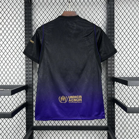 Vista trasera de la camiseta Barcelona 26-27 visitante, con degradado de negro a morado y detalle dorado en la parte baja