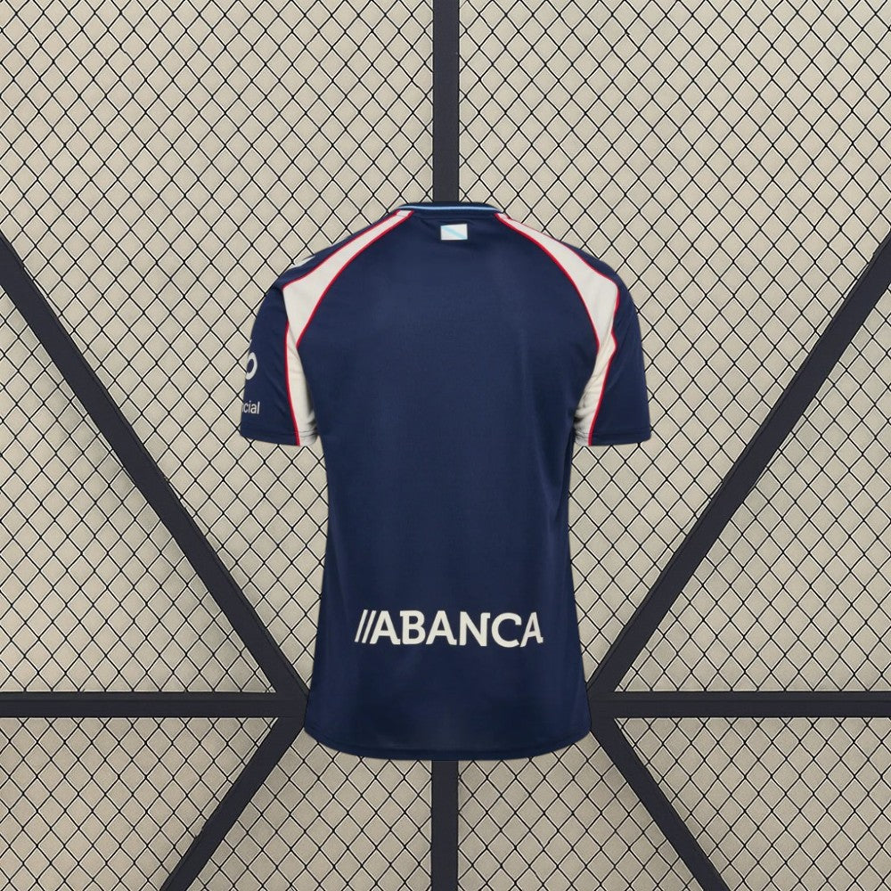 Vista trasera de la camiseta Celta de Vigo 26-27 visitante en color azul marino, con paneles claros en los hombros y mangas