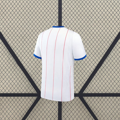 Vista trasera de la camiseta Chelsea 26-27 3ª equipación blanca con líneas verticales rojas y detalles azules en las mangas