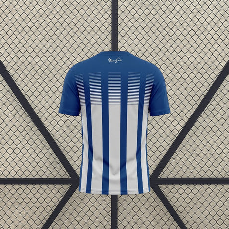 Vista trasera de la camiseta Huelva 26-27 Local con franjas verticales azules y blancas y parte superior azul