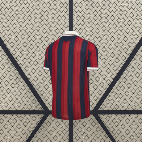 Vista trasera de la camiseta Levante UD 26-27 Local con franjas verticales rojas y azul marino y cuello blanco