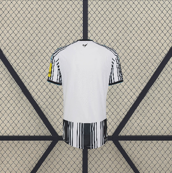 Vista trasera de la camiseta Newcastle 26-27 local con zona superior blanca, mangas a rayas y franjas negras en la parte inferior