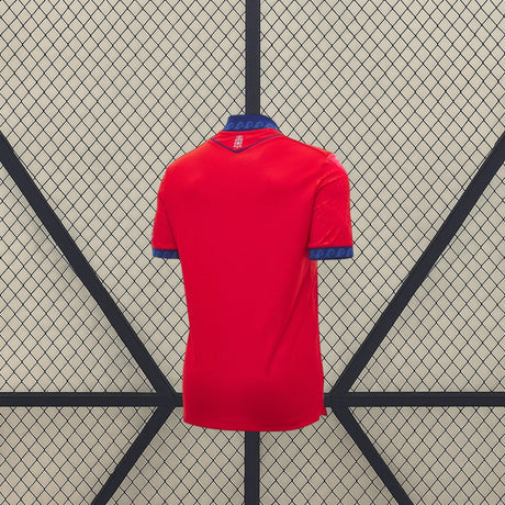 Vista trasera de la camiseta Osasuna 26-27 local en color rojo, con cuello y puños azules y pequeño detalle gráfico bajo el cuello