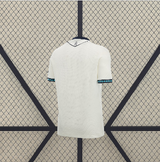 Vista trasera de la camiseta Osasuna 26-27 visitante en blanco con espalda lisa, cuello oscuro y detalles en los puños