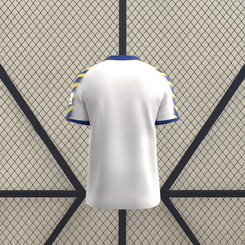 Vista trasera de la camiseta Parma 25-26 tercera equipación en color blanco, con cuello azul y mangas estampadas en azul y amarillo