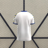 Vista trasera de la camiseta Parma 25-26 tercera equipación en color blanco, con cuello azul y mangas estampadas en azul y amarillo