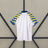 Vista trasera de la camiseta Parma 25-26 tercera equipación mostrando la espalda lisa blanca y las mangas con franjas azules y amarillas