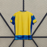 Vista trasera de la camiseta Parma 25-26 visitante, predominantemente amarilla, con paneles laterales azules y franja difuminada en el bajo