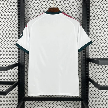 Vista trasera de la camiseta R.M. 26-27 local en blanco, con hombros granate y ribetes verde oscuro en cuello y mangas
