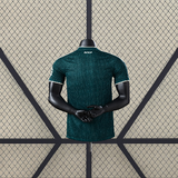 Vista trasera de la camiseta R.M. 26-27 visitante Player Version en verde oscuro, con manga corta y diseño tonal
