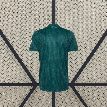 Vista trasera de la camiseta R.M. 26-27 visitante en verde oscuro, con textura geométrica tonal y detalle dorado bajo el cuello